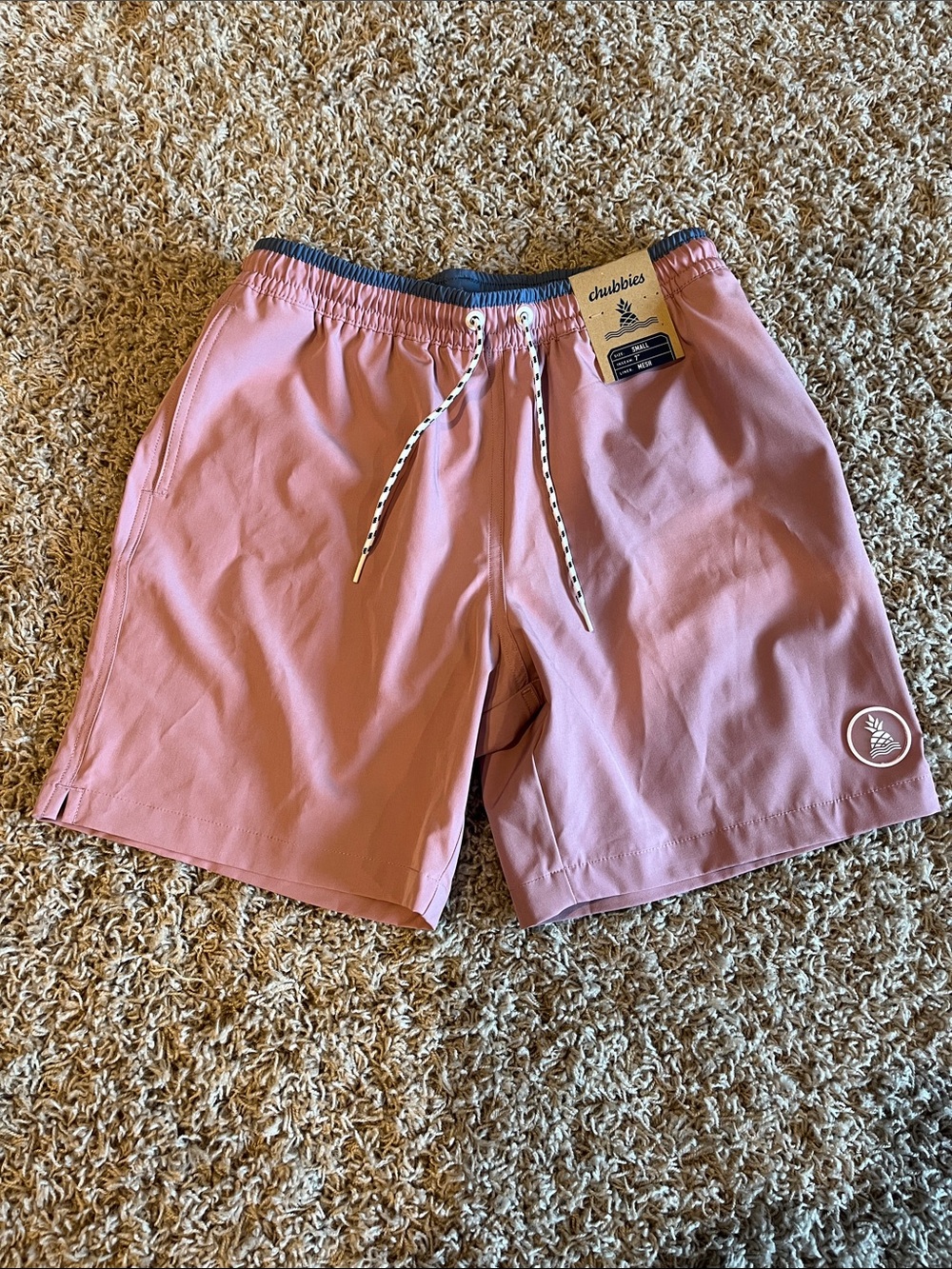 Chubbies men’s adult small swim trunks. Pink base with blue streak at the top.
